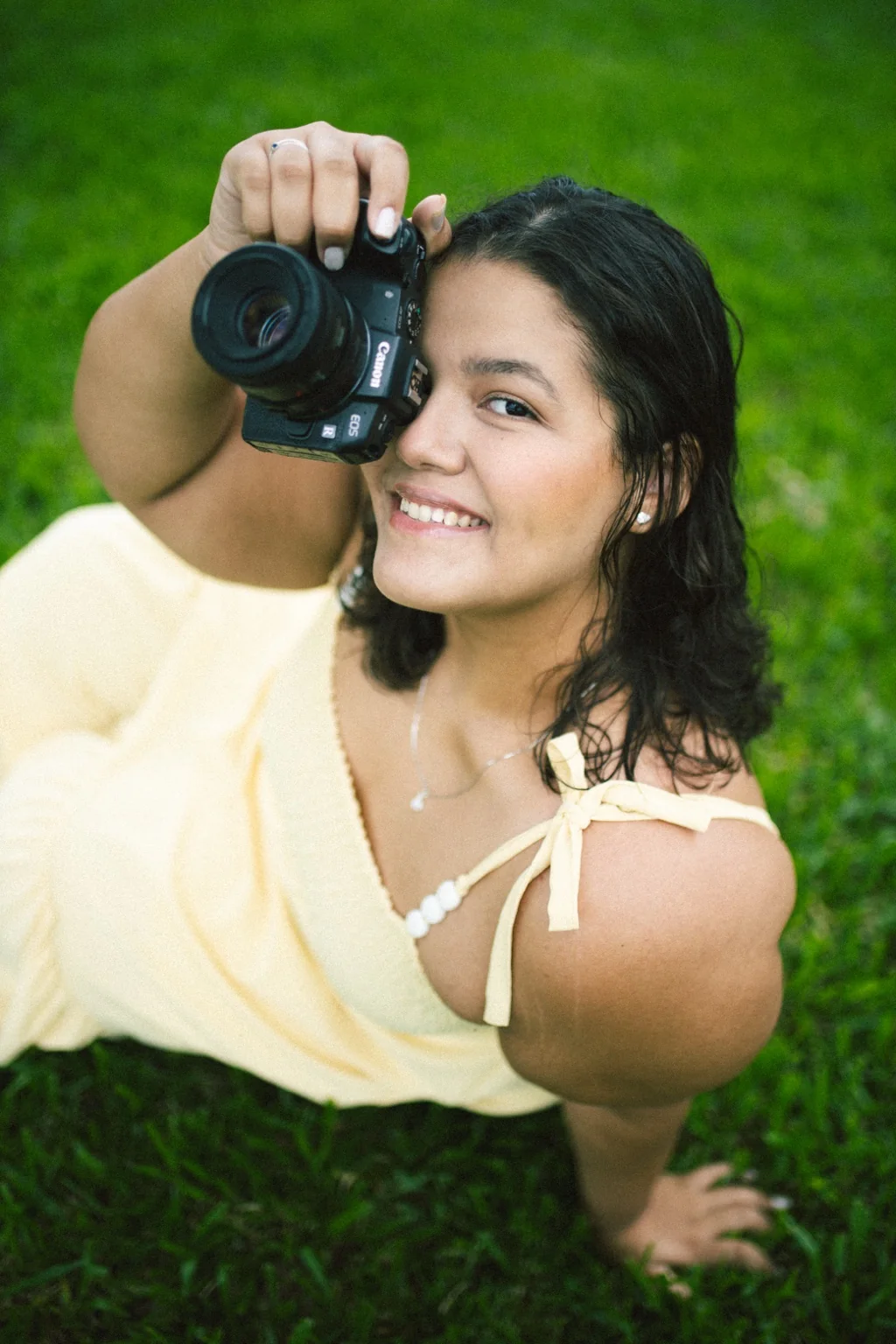 Lívia fotografando com uma câmera Canon